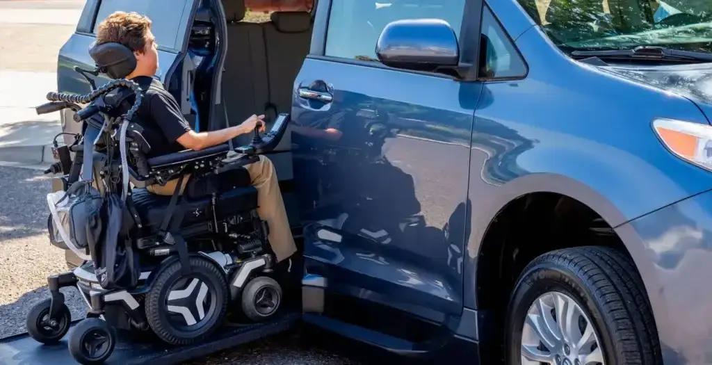 Person in a motorized wheelchair entering a van with a ramp.