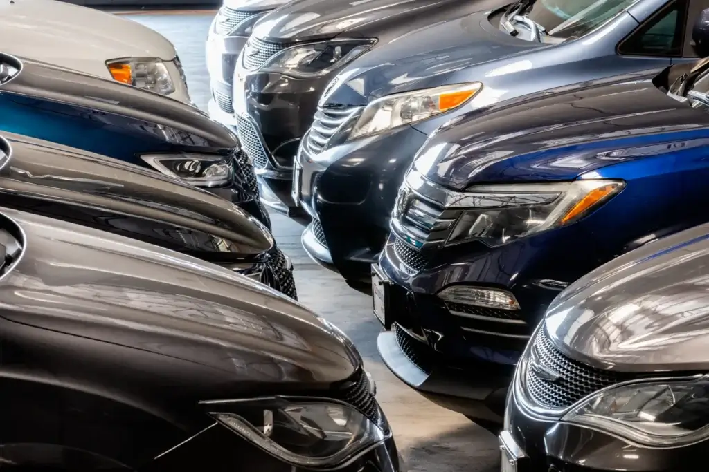 Close-up of multiple parked cars in two rows, facing each other in a parking area.